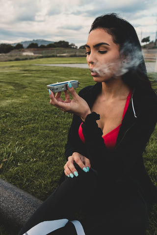 Woman using a convection vaporizer on a golf course